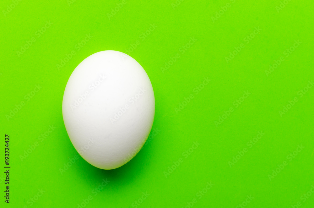 White egg on a bright green background. White egg on a bright green background.