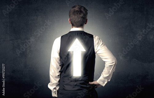 Young businessman standing with arrow on his back