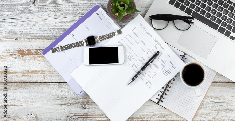Overhead view of office desktop preparing to do income taxes on white rustic wooden desk Overhead view of office desktop preparing to do income taxes on white rustic wooden desk