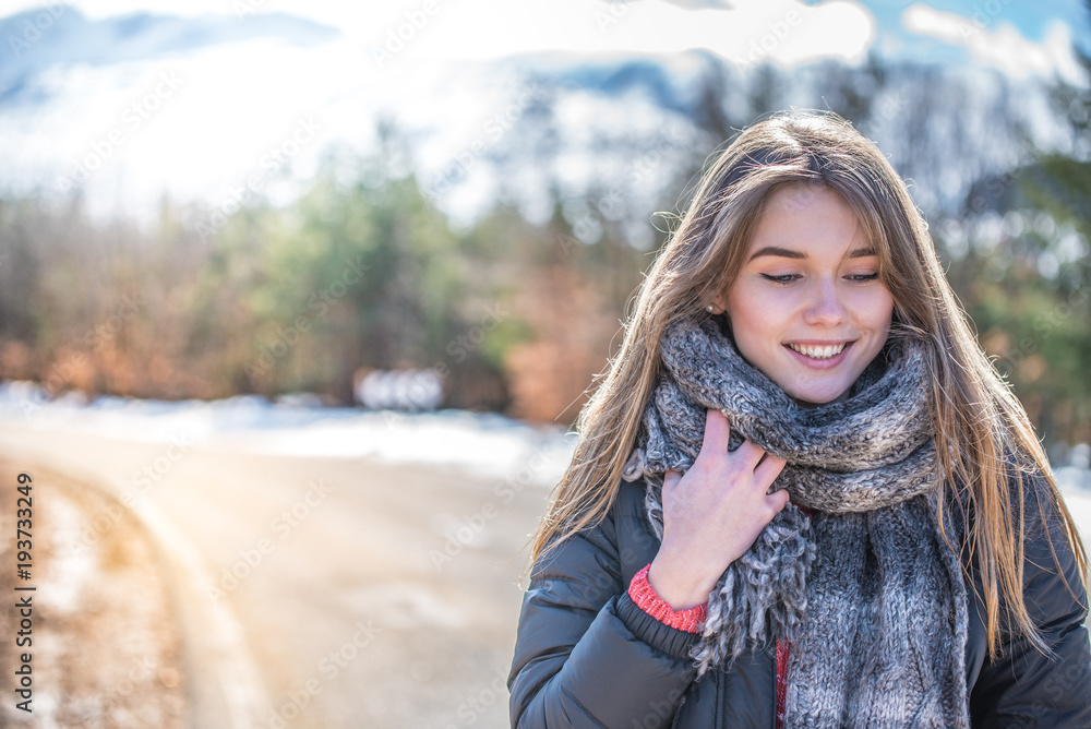 Young pretty woman on a road with snow in winter Young pretty woman on a road with snow in winter