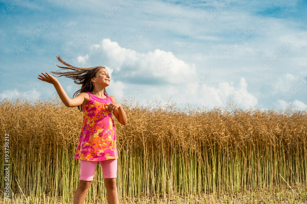 Happy little girl in a field of ripe rapeseed Happy little girl in a field of ripe rapeseed