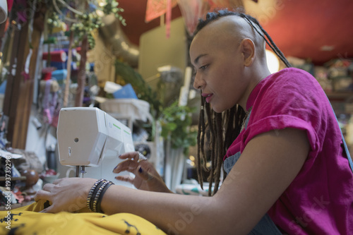 Side view of young female designer working at studio