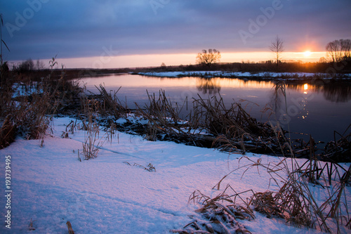 amazeing coloured winter sunrise against snowy river