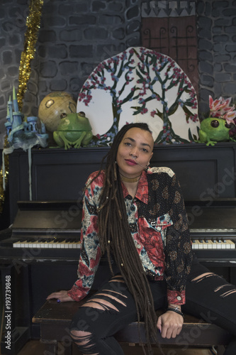 Portrait of young woman sitting in front of piano