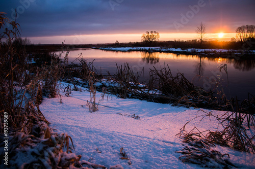 amazeing coloured winter sunrise against snowy river