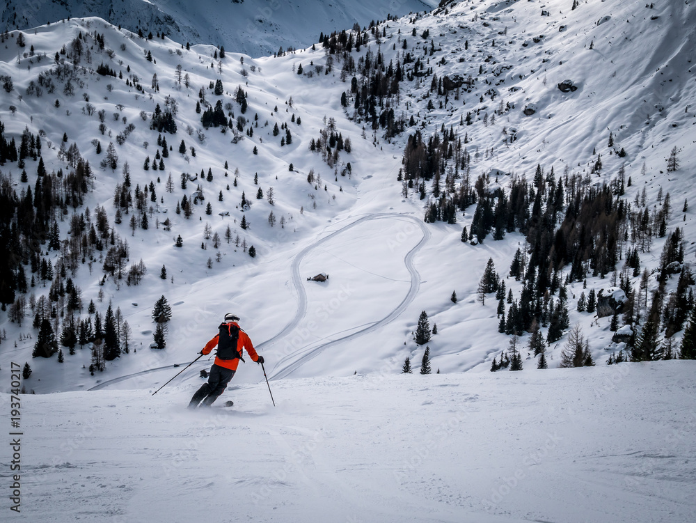 Freeride skier riding in snow in piste downhill in the Italien Alps around Canazei.