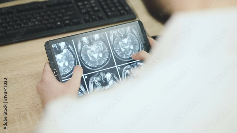 A doctor who is observing a patient's MRI examination A doctor who is observing a patient's MRI examination