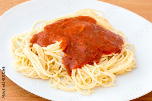 Simple tomato spaghetti on white plate.