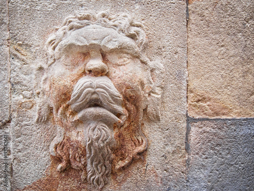 Photography Bas-relief on ta wall of the face of an antique Greek god