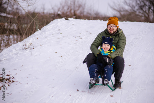 Father And Son Sitting On Sledge photo