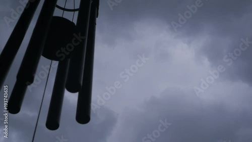Wind chimes with thunder storm clouds in the background.