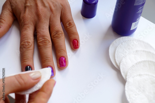 Washing nail polish from a woman s hand. Remover and cotton swab