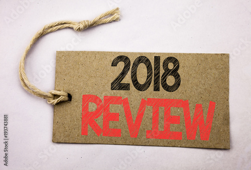 Hand writing text caption inspiration showing 2018 Review. Business concept for Feedback On Progress written on price tag paper on the white vintage background. photo