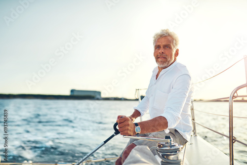 Mature man sitting alone on the deck of his sailboat