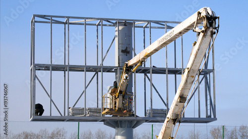 Construction site and big billboard. People Working Building New Big Billboard. Worker repairing billboard. Construction of LCD screen billboard photo