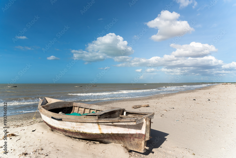 abandoned fishing boat on the shore of a beach in Colombia