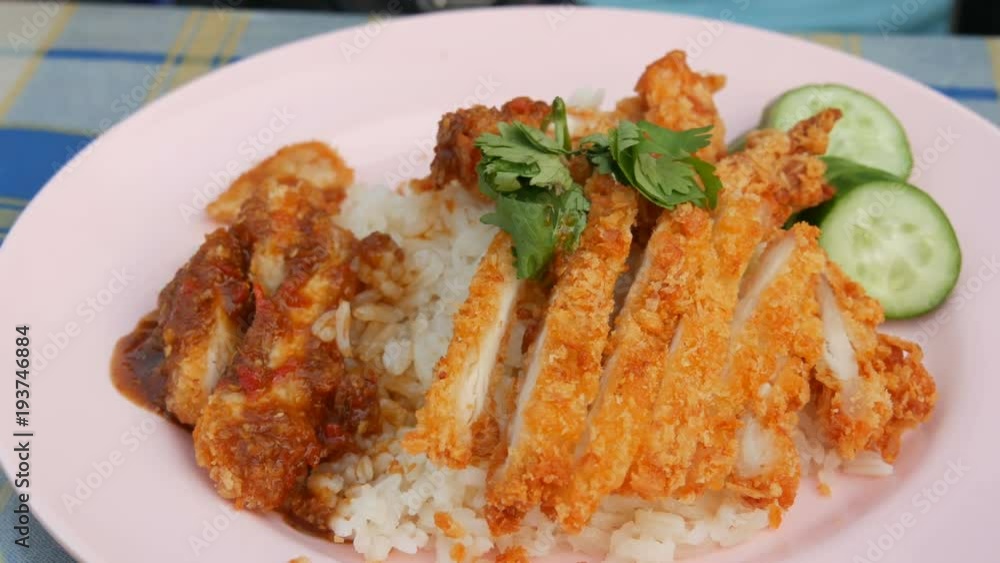 A man eats a fork with Thai food. Rice with pea pods and fried crispy chicken on breading A man eats a fork with Thai food. Rice with pea pods and fried crispy chicken on breading