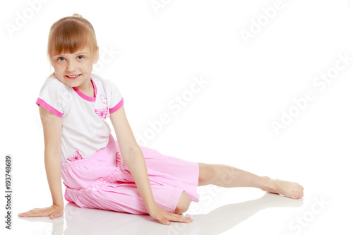 Little girl is sitting on the floor.