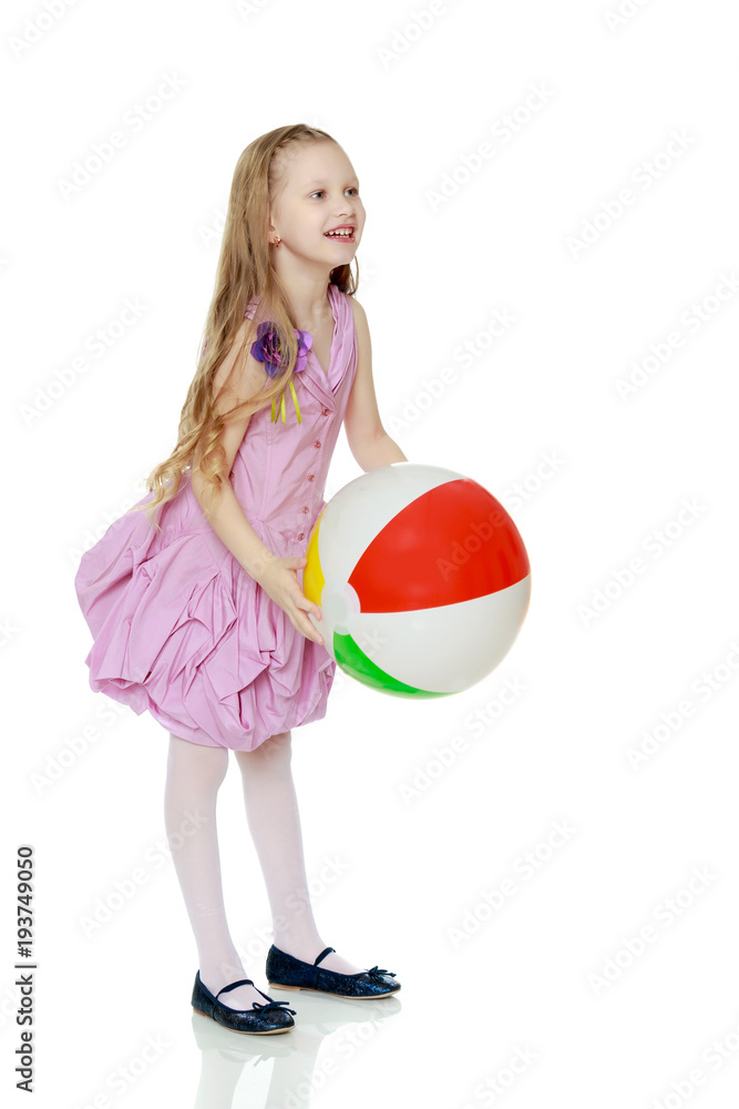 Beautiful little girl with a large multi-colored inflatable ball Beautiful little girl with a large multi-colored inflatable ball