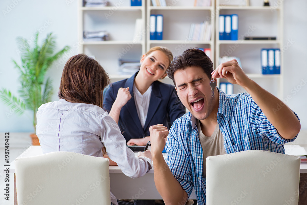 Young family agreeing mortgage contract in the bank for new house Young family agreeing mortgage contract in the bank for new house
