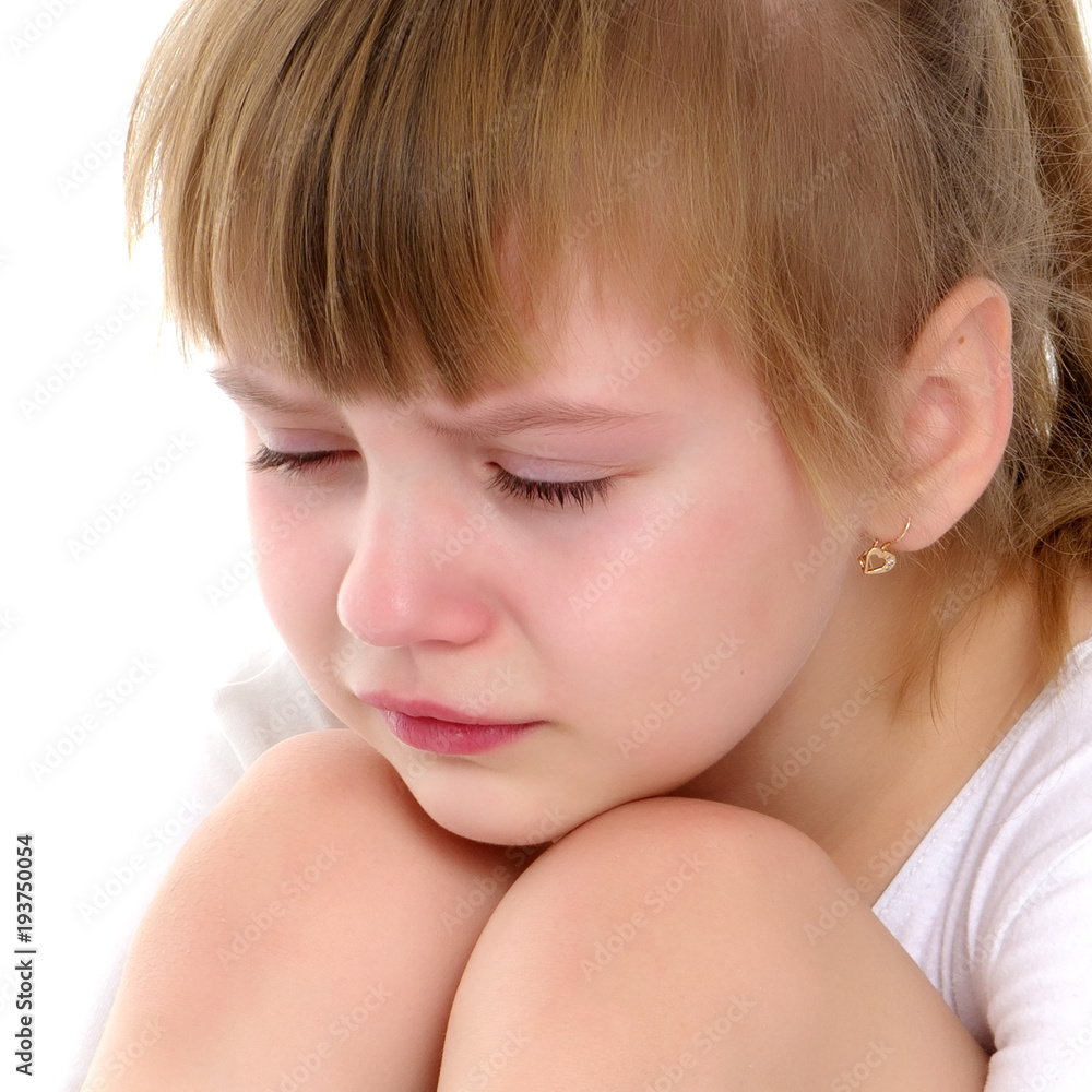 Girl gymnast sits on the floor and cries Girl gymnast sits on the floor and cries