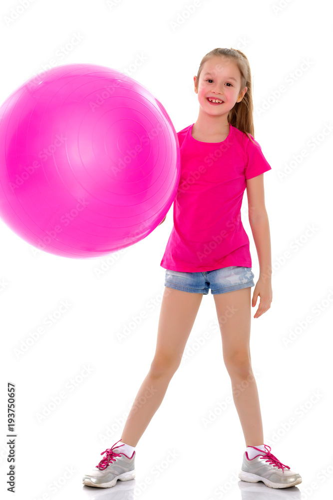little girl doing exercises on a big ball for fitness. little girl doing exercises on a big ball for fitness.
