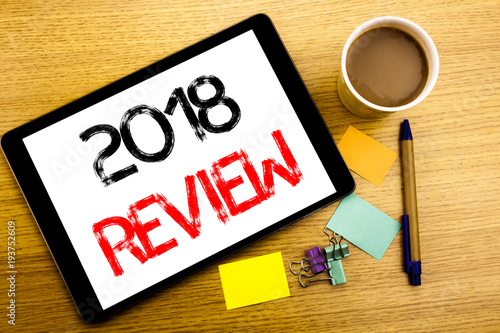 Handwritten text caption showing 2018 Review. Business concept writing for Feedback On Progress Written on tablet laptop, wooden background with sticky note, coffee and pen