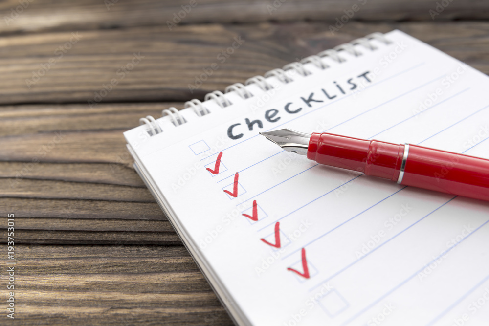 checklist, pen on a wooden background. business. finance. planning. checklist, pen on a wooden background. business. finance. planning.