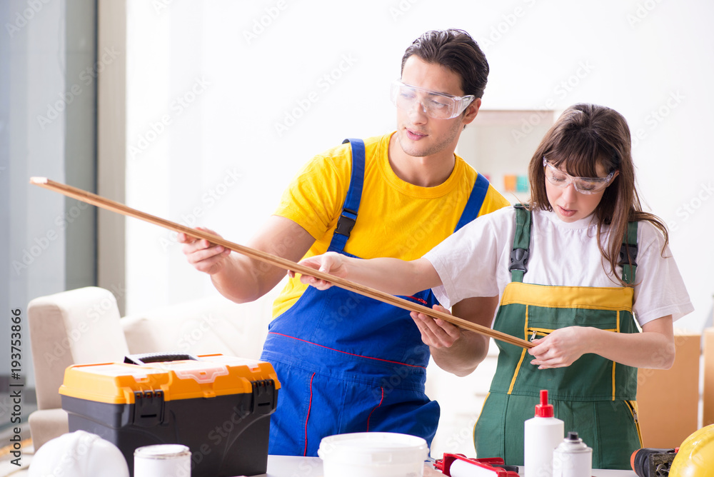 Man explaining woman woodworking tips in wood workshop Man explaining woman woodworking tips in wood workshop