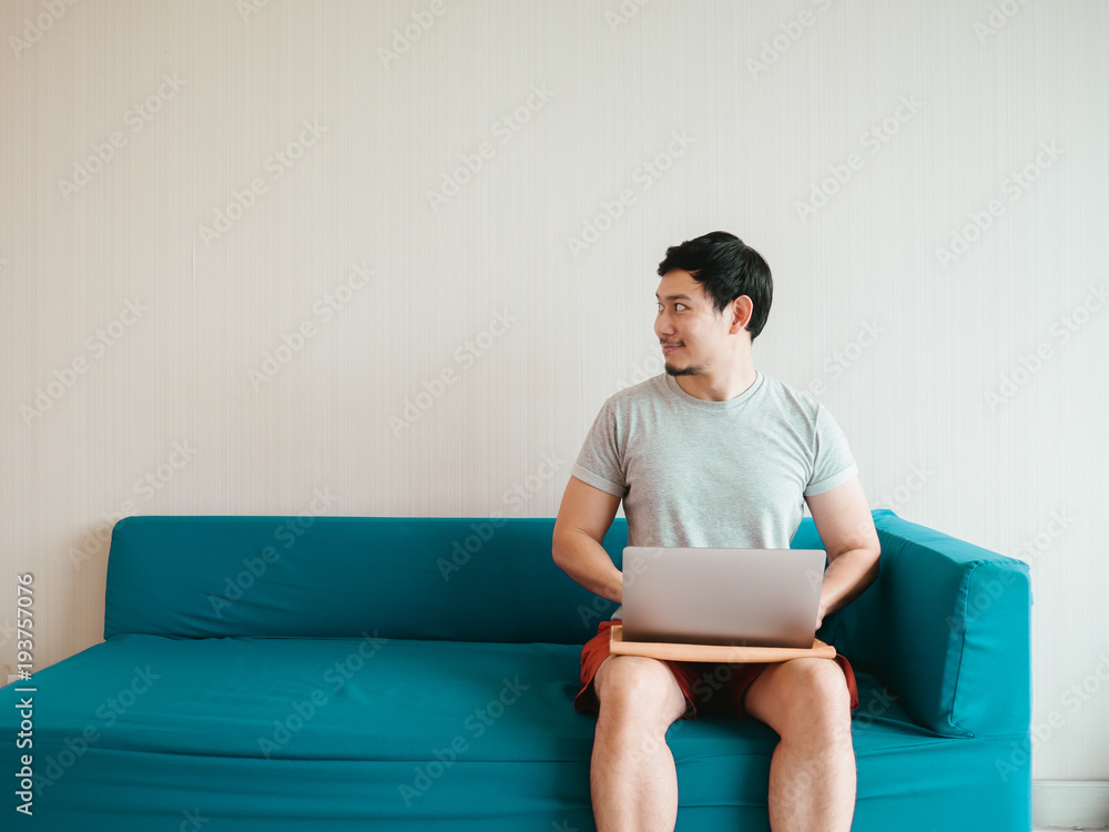 Man is using laptop on the sofa in his casual cloth. Man is using laptop on the sofa in his casual cloth.