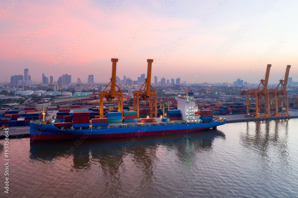 Fototapeta premium Aerial view of Containers yard in port congestion with ship vessels are loading and discharging operations of the transportation in international port.Shot from drone.