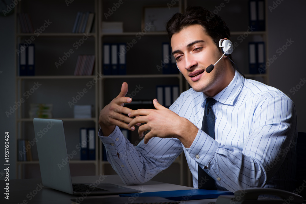 Call center operator talking to customer during night shift Call center operator talking to customer during night shift