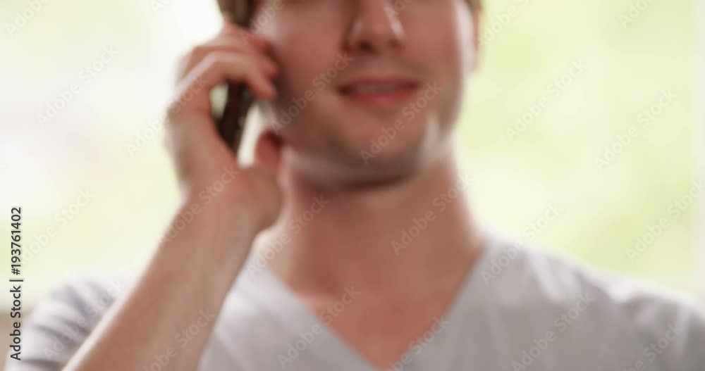 4k, Attractive young man relaxing at home and chatting on his mobile phone. 4k, Attractive young man relaxing at home and chatting on his mobile phone.