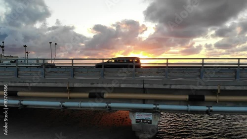 Cars on bridge at sunset overlooking the ocean