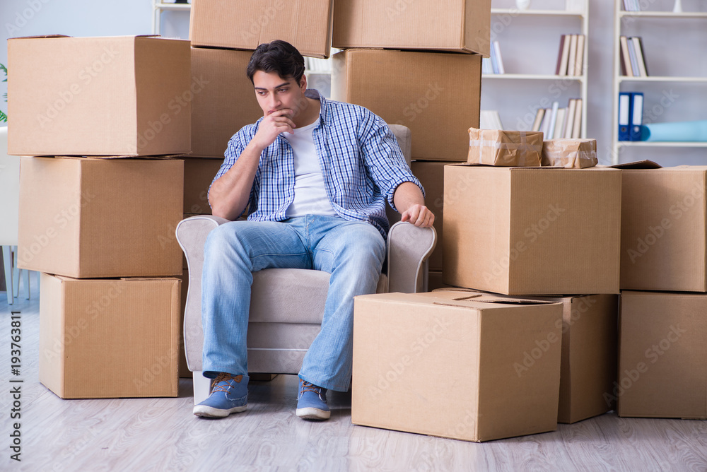 Young man moving in to new house with boxes Young man moving in to new house with boxes