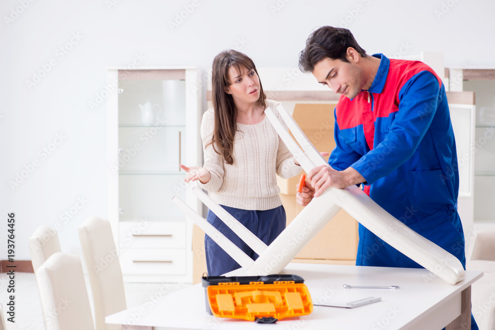 Contractor repairman assembling furniture under woman supervisio Contractor repairman assembling furniture under woman supervisio