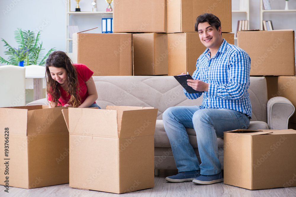 Young pair moving in to new house with boxes Young pair moving in to new house with boxes
