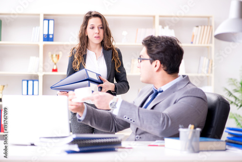 Businessman asking for paperwork from his assistant secretary