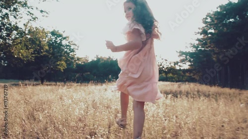 The little girl runs along the path in the park. happy girl running around. sunset light