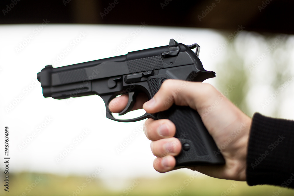 Killer with gun close up over grunge background with copyspace. Killer with gun close up over grunge background with copyspace.