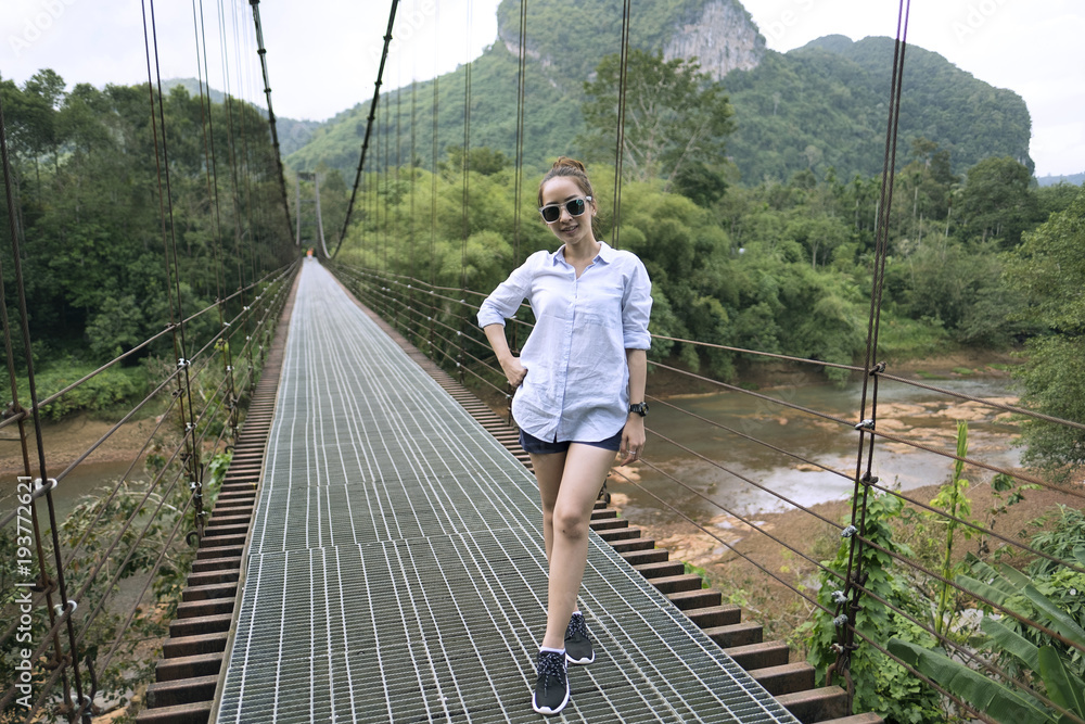 Naklejka premium traveler teen girl posing on the bridge and nature in weekend holiday