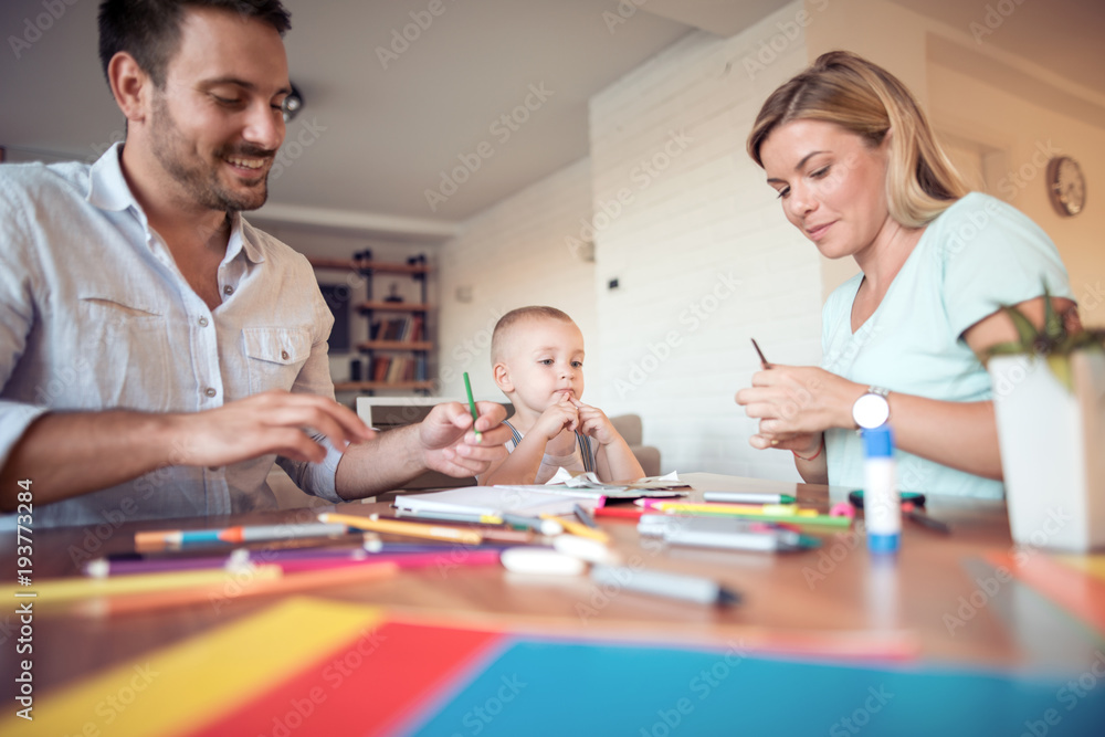 Fototapeta premium Parents with a son drawing and color