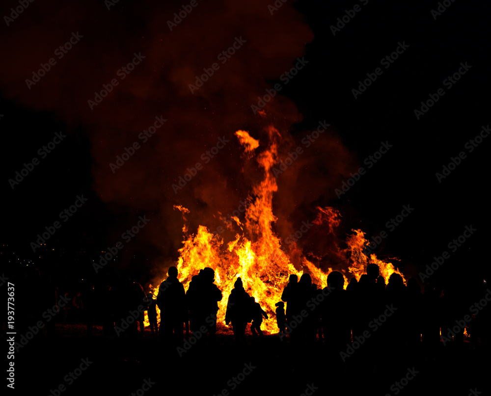 Obraz premium silhouettes of people in frontof big fire