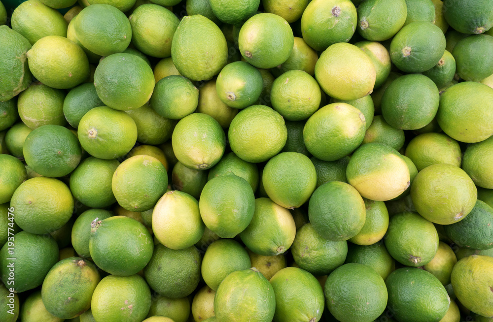 Pile of fresh lime lemon in market for sale. top view. Lime Citrus Fruits on display at Fruit Market Pile of fresh lime lemon in market for sale. top view. Lime Citrus Fruits on display at Fruit Market