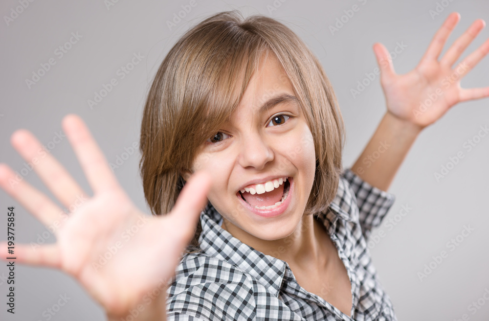 Emotional portrait of little girl celebrating, gesturing, keeping arms raised and expressing positivity. Funny teenager, on gray background. Lucky schoolgirl, shouting with her hands up. Emotional portrait of little girl celebrating, gesturing, keeping arms raised and expressing positivity. Funny teenager, on gray background. Lucky schoolgirl, shouting with her hands up.