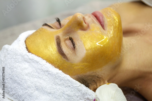 Beautiful woman with facial mask at beauty salon