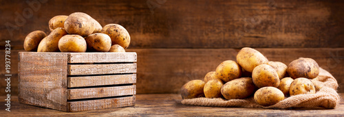 fresh raw potatoes in a wooden box