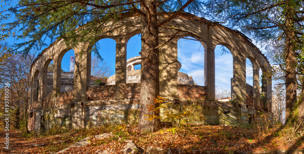 The arcade of the abandoned building of the former restaurant on the top of Mount Akhun in sunny autumn day, Sochi, Russia
