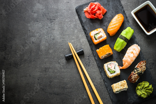 Sushi and sushi roll set on black stone table top view