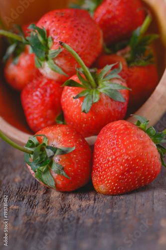 Close up of fresh organic strawberries in wooden bowl.